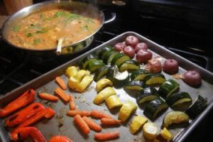 pan of roasted veges with pan of healing indian chicken