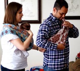 doula wearing baby helps dad